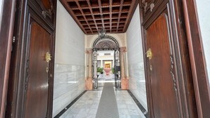 A hallway with marble flooring, wooden doors, and a decorative ceiling. - APARTMENT PALACIO DE LOS VIBORA (Lucena)