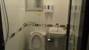 A small bathroom with a toilet, sink, and shower. - Davao Hostel (Kowloon)