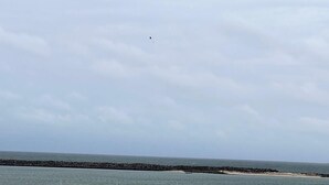 Une vue sur la côte, avec une digue rocheuse et une mer calme.