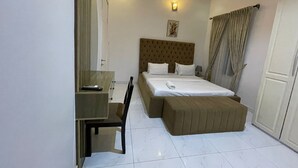 Une chambre d’hôtel avec un lit, un bureau et une chaise.