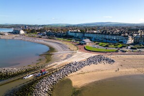 Un pueblo costero con un puerto deportivo, edificios residenciales y una playa.