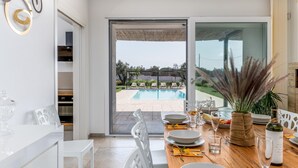 A dining area with a view of a swimming pool and outdoor seating. - Villa I Chiani 8 Emma Villas (Gagliano del Capo)