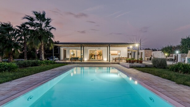 A modern house with a swimming pool, surrounded by palm trees and a well-maintained garden. - Villa I Chiani 8 Emma Villas (Gagliano del Capo)