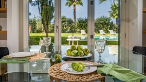 A dining table with plates of prickly pears, a glass, and a woven placemat. - Casavento Puzziteddu 6 Emma Villas (Campobello di Mazara)