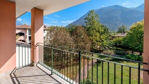 A balcony with a view of a mountain and a garden. - Porto Letizia Rossini 9, Porlezza, Italy (Porlezza)