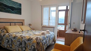 A bedroom with a bed, a chair, a window, and a view of the outside. - La Rectoral Arriondas 2 (Arriondas)