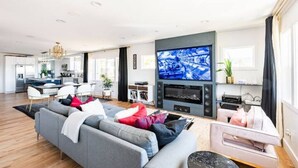 A modern living room with a grey sofa, a flat-screen TV, and a fireplace.