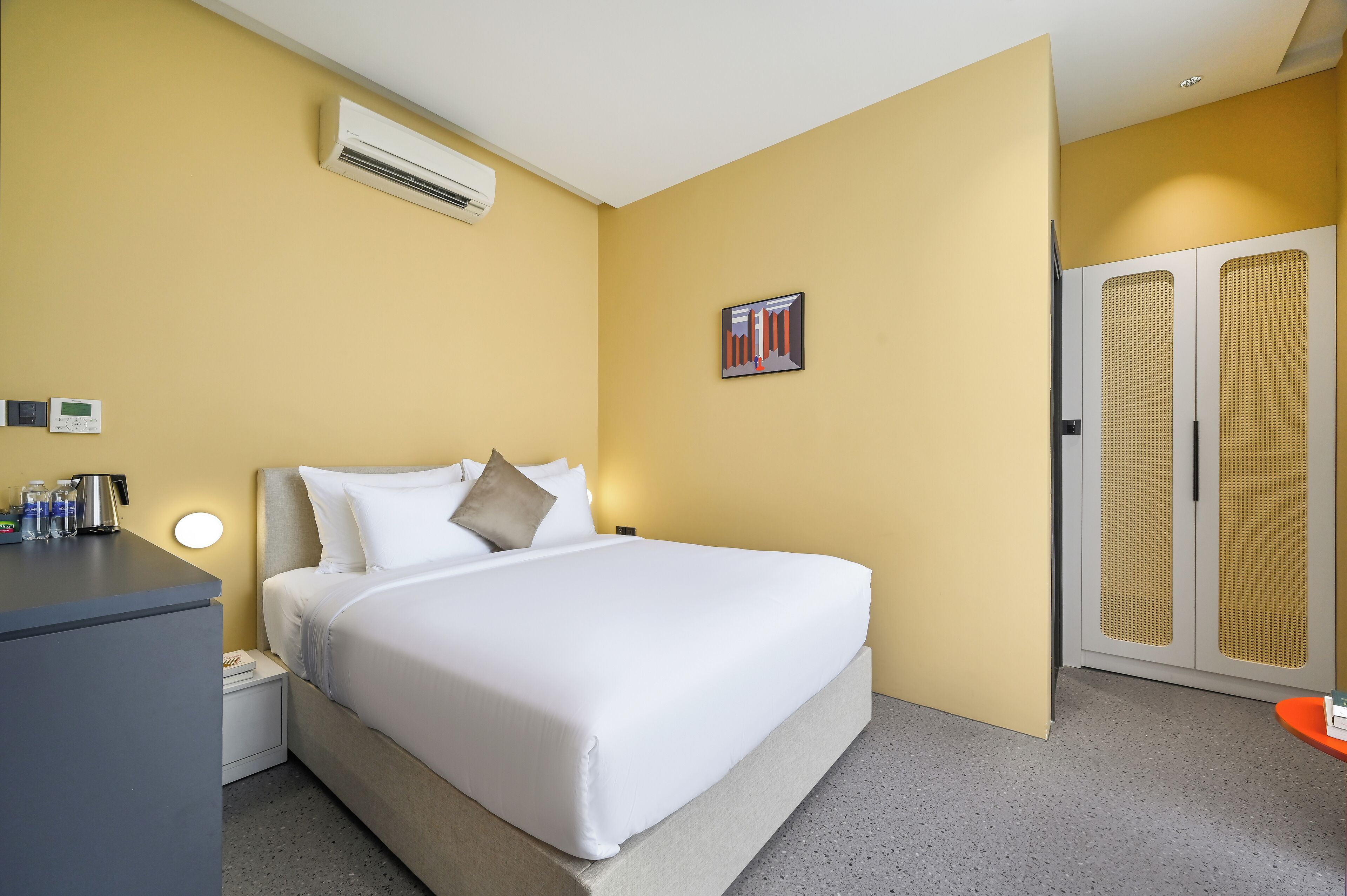Ein Hotelzimmer mit Bett, Nachttisch und Klimaanlage.