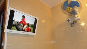 A television mounted on a wall displaying a scene with a person on a horse. - Bohol Hostel (Kowloon)