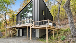 A modern two-story cabin with a balcony and a garage. - Black Diamond: "Waterfront Finger Lakes Home with Hot Tub!" (Hector)