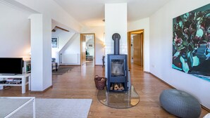 Una sala de estar con chimenea, televisor y un cuadro grande en la pared.