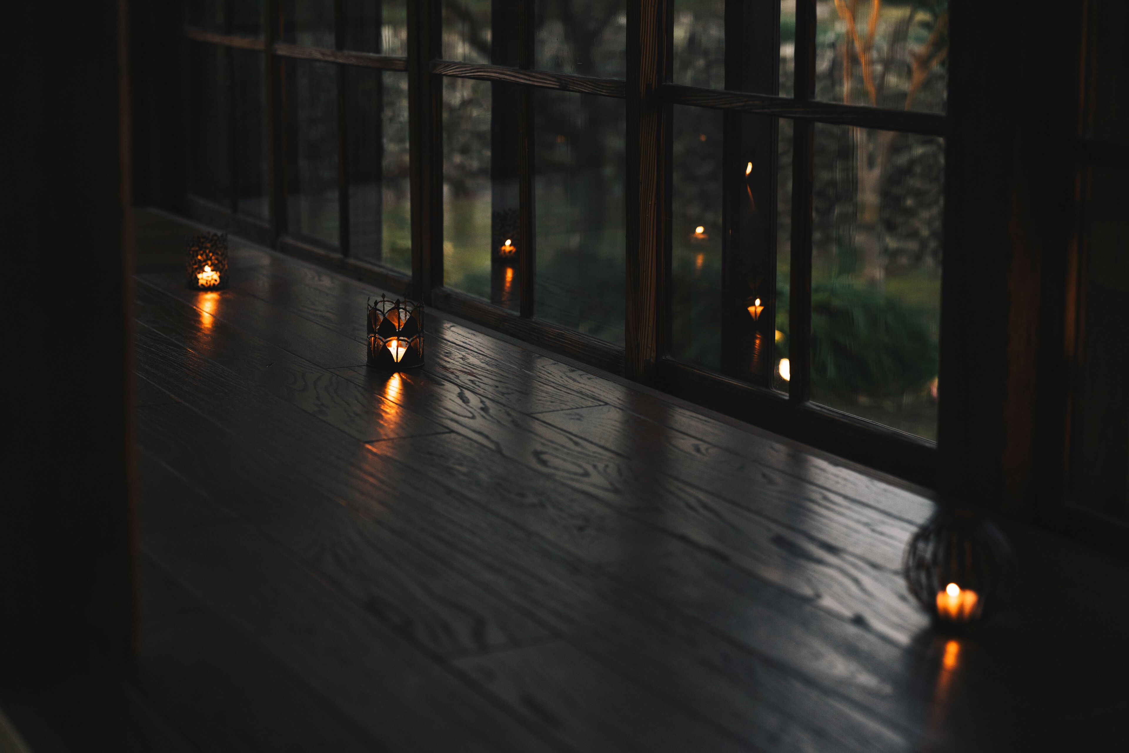 A room with a wooden floor and large windows.