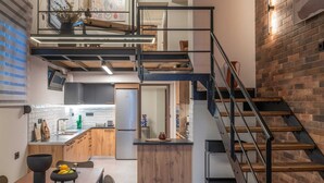 A modern kitchen with wooden cabinets, a black countertop, and a dining area with a table and chairs.