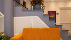 Eine moderne Lobby mit einer Couch, einer Treppe und einer Topfpflanze.