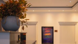 Ein modernes Interieur mit einer Treppe, einem Blumentopf, einem gerahmten Kunstwerk und einer Tür mit der Nummer 101.