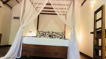 A bed with a canopy, a bedside table, and a wall-mounted light fixture.