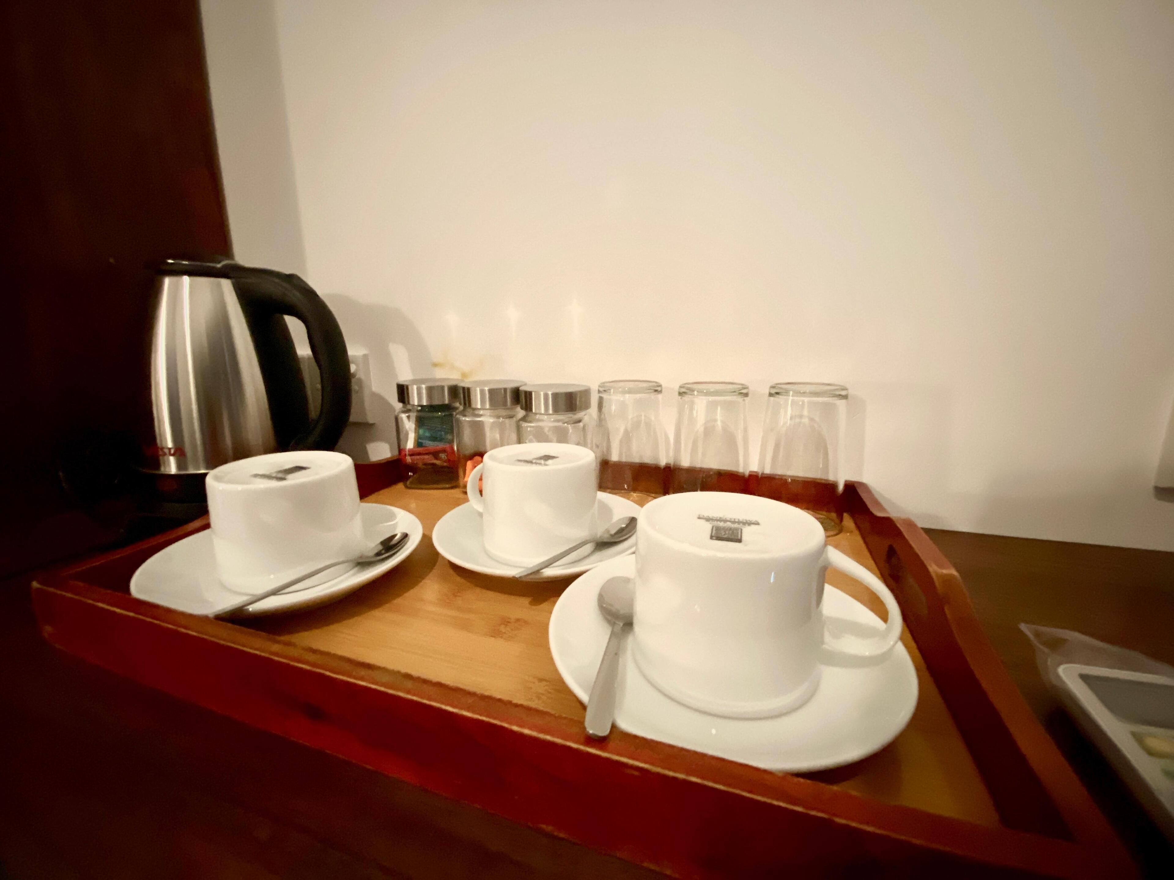 A tray with a tea set including cups, saucers, and a teapot.