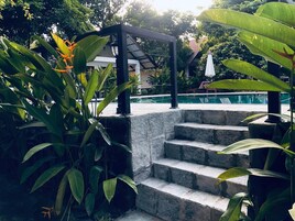 Una piscina al aire libre, sombrillas, sillones reclinables de piscina