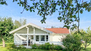 A white house with a red-tiled roof, a covered porch, and a lawn. - Stunning home in Borgholm with WiFi (Borgholm)