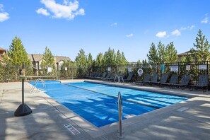 Piscina con recinzione, sedie a sdraio e un cartello che indica la capienza.