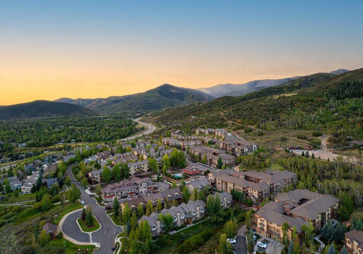 A residential area with houses, roads, and a mountainous backdrop.