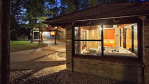 A rustic cabin with a glass-enclosed hot tub and a stone fireplace. - Gorgeous home in Gustelnica with sauna (Gustelnica)