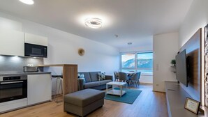 A modern apartment with a kitchen, living area, and dining space.