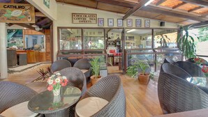 An outdoor seating area with wicker furniture and potted plants. - Honiara Hotel (Honiara)