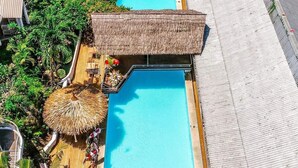 A resort with two swimming pools, thatched umbrellas, and a wooden deck. - Honiara Hotel (Honiara)