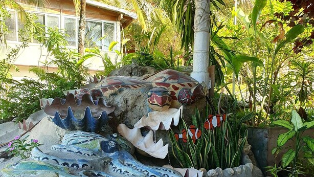 A rock garden with painted turtles and fish, surrounded by tropical plants. - Honiara Hotel (Honiara)