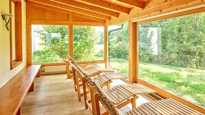 Un interior de madera con amplios ventanales que dan a un jardín.
