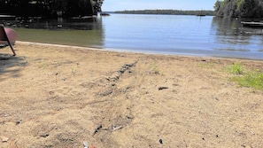 A sandy beach with a chair and a small boat.