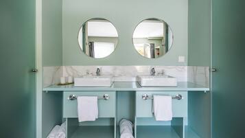 Un baño con dos lavamanos, dos espejos y una encimera de mármol.