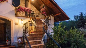 A staircase leading to a wooden deck with potted plants and a stone wall. - Villa Agnes (Myslenice)