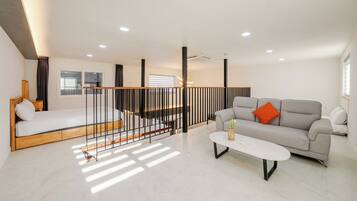 Una sala de estar moderna con un sofá, una cama, una mesa de centro y una escalera.
