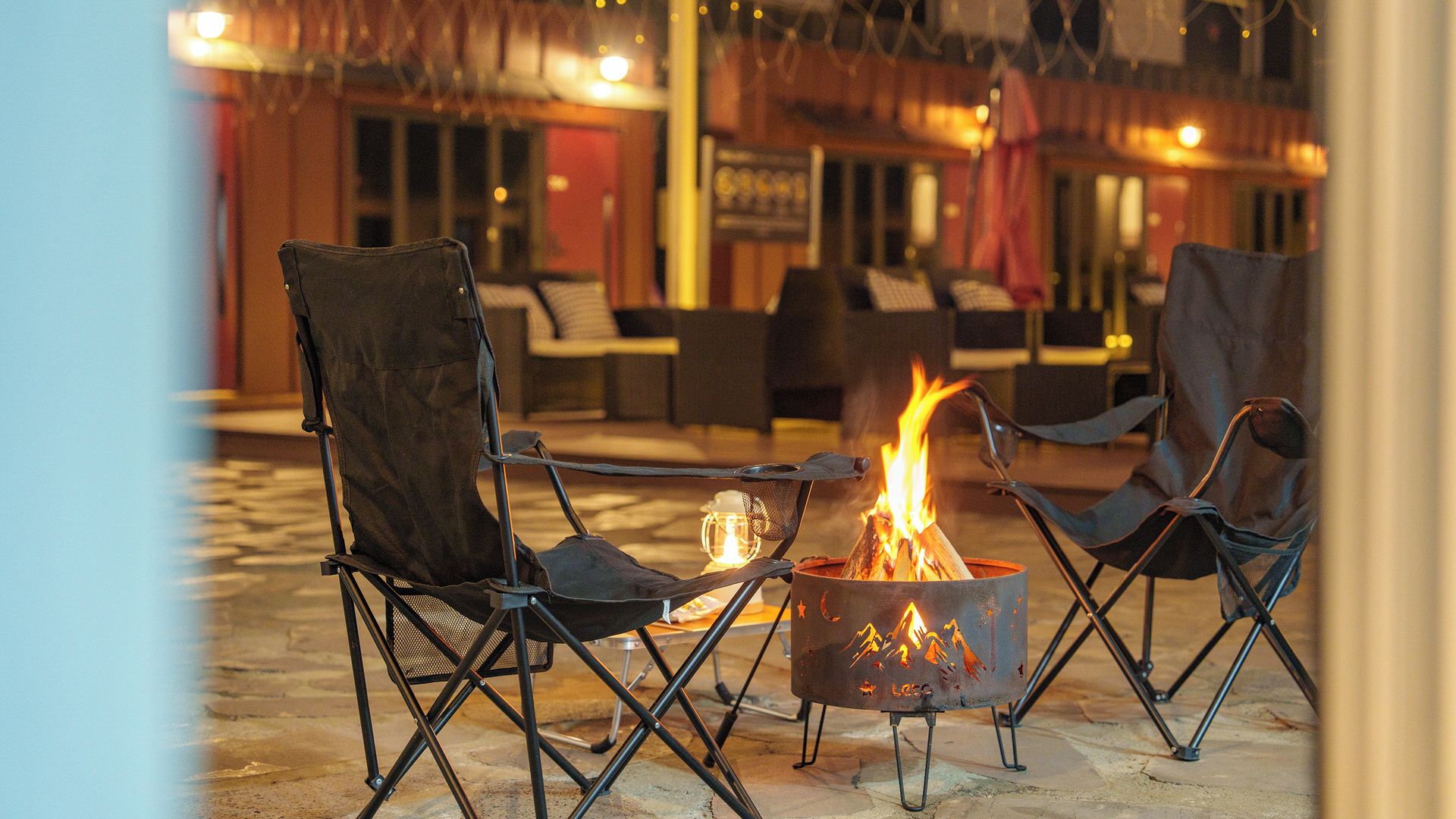 An outdoor seating area with a fire pit and chairs.
