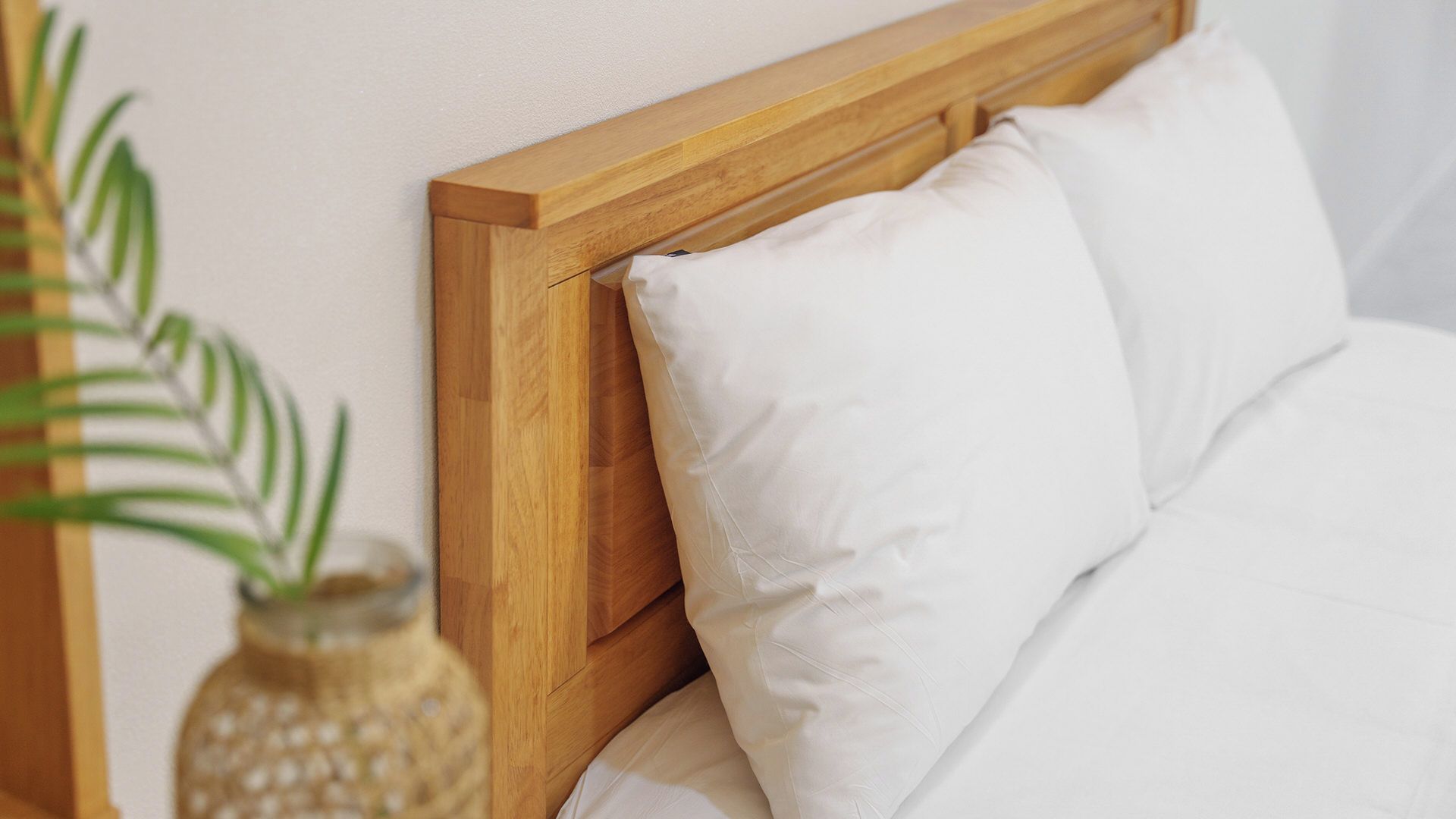 A bed with a wooden headboard and white bedding.