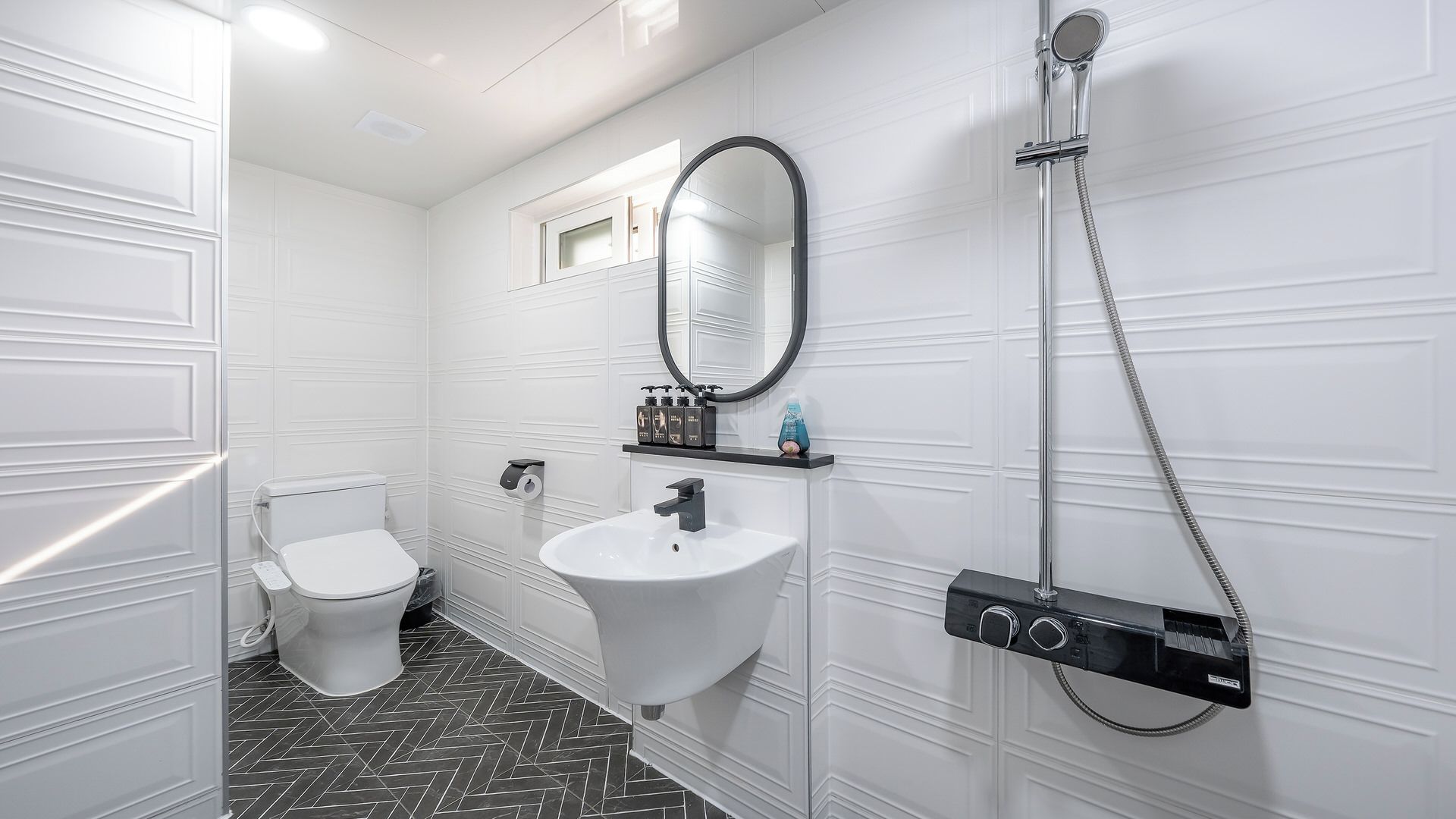 Un baño moderno con inodoro, lavabo y ducha.