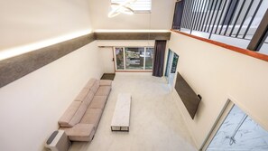 Ein modernes Interieur mit einer Couch, einer Bank und einem großen Fenster.