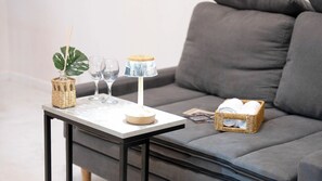Ein kleiner Tisch mit einer Lampe, Gläsern und einer Pflanze.