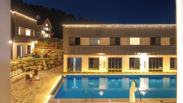 A two-story building with a swimming pool in front.