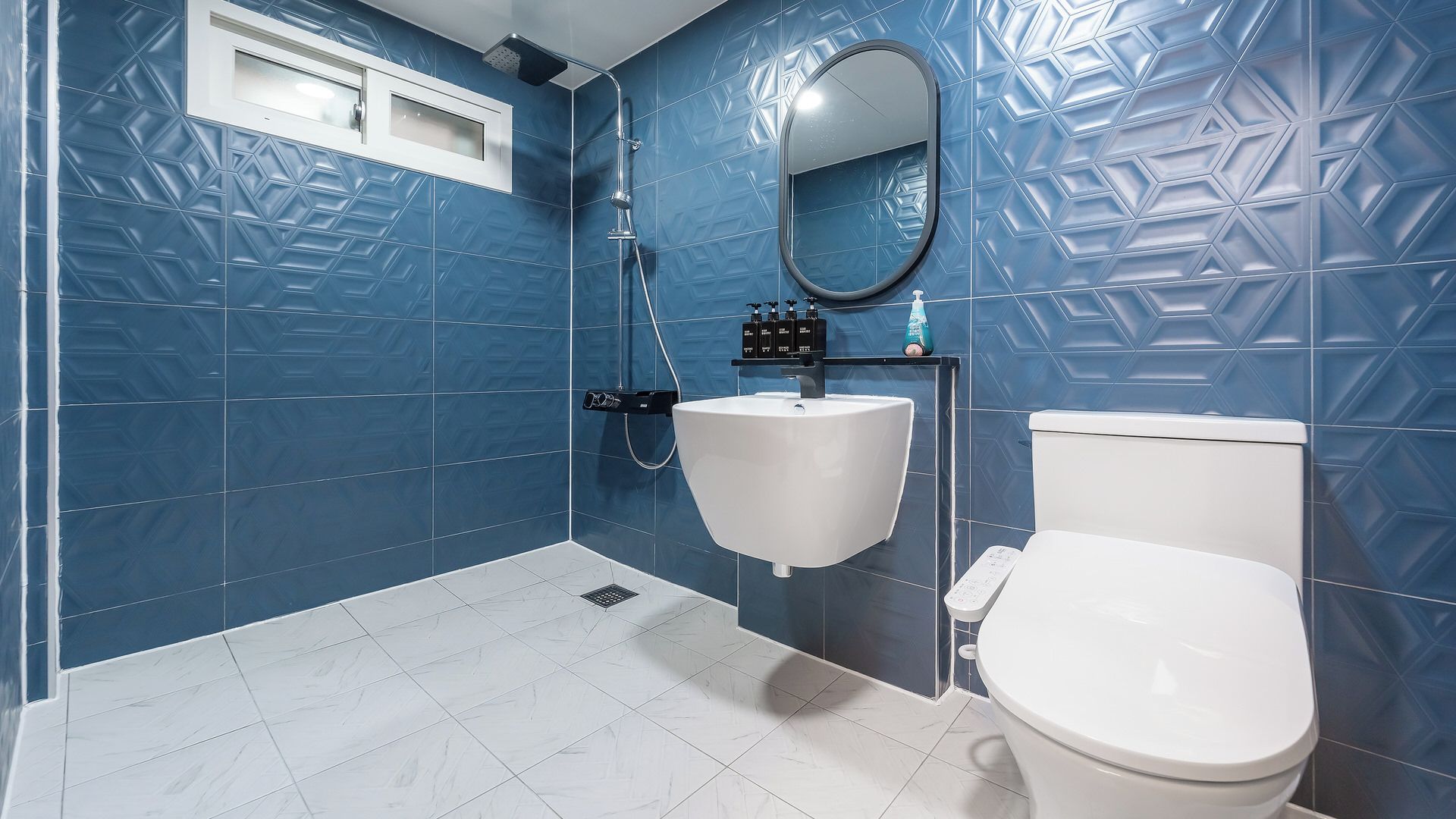 A bathroom with a white sink, toilet, and shower.