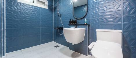 A bathroom with a white sink, toilet, and shower.