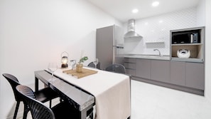 A modern kitchen with a built-in microwave, a stainless steel range hood, and a countertop with a sink. - Gapyeong Orion Poolvilla Pension (Gapyeong)