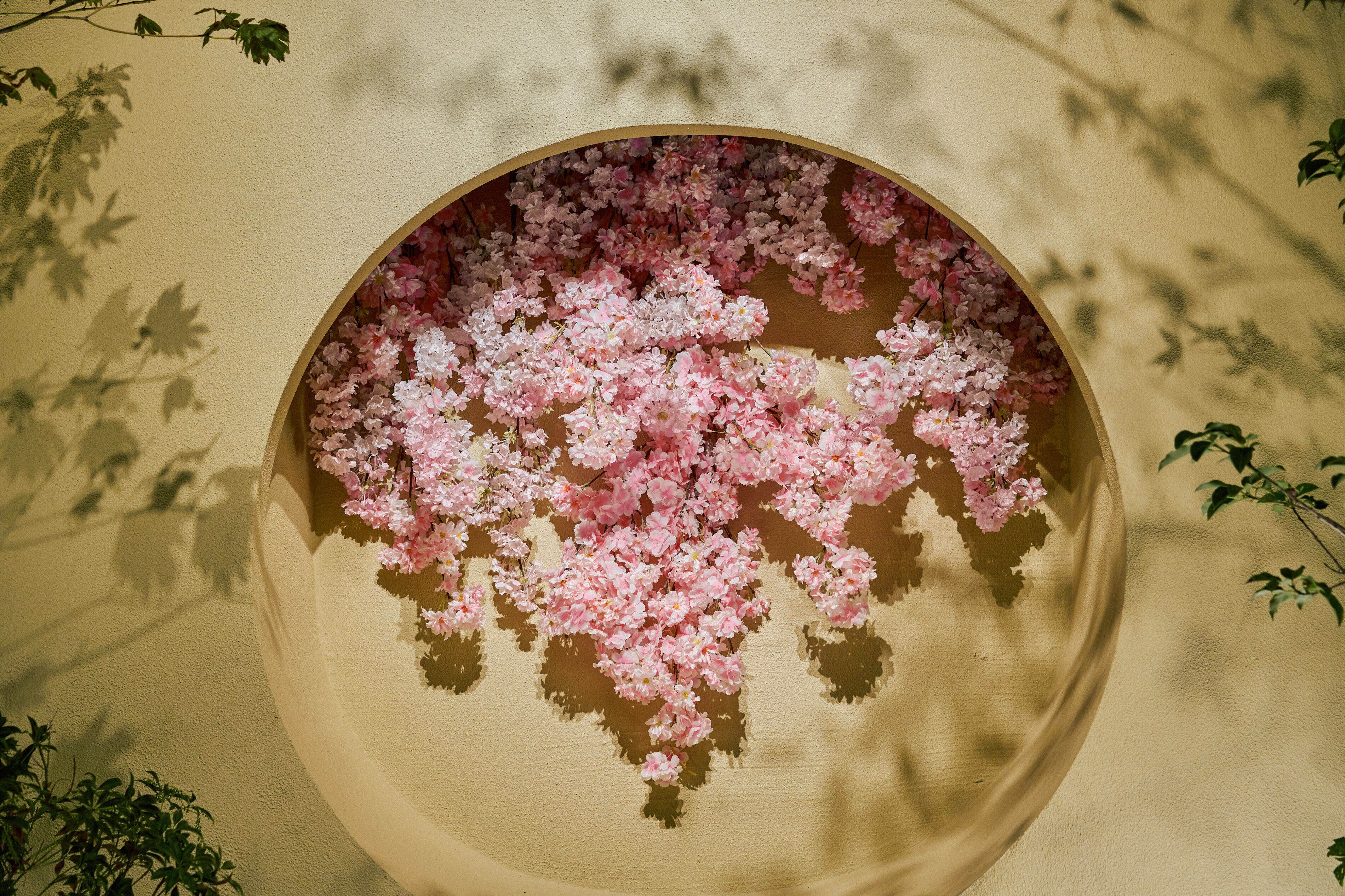 Una estructura de madera circular con flores rosas en la parte superior.