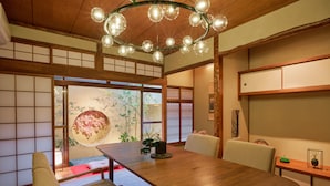 Et traditionelt japansk rum med tatamimåtter, et træspisebord og en shoji skærmdør.