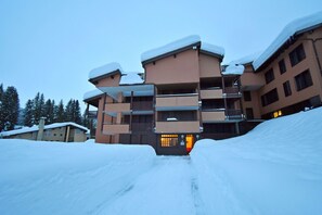 Hotel entrance with a warm glow, featuring a welcoming door and inviting balconies.