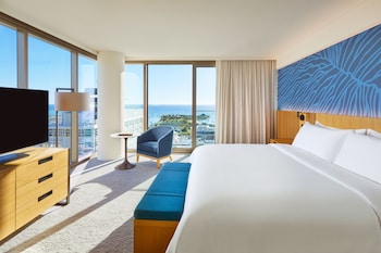 A modern kitchen with a central island, a built-in oven, and a view of the city through large windows. at Renaissance Honolulu Hotel & Spa
