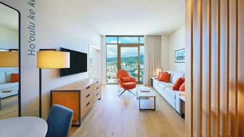 Ein modernes Hotelzimmer mit Blick auf die Stadt, einem Flachbildfernseher, einer Couch, einem Esstisch und einem Stuhl.