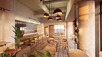 Ein modernes Restaurantambiente mit Holztischen und -stühlen, Pendelleuchten und großen Fenstern, die für natürliches Licht sorgen.